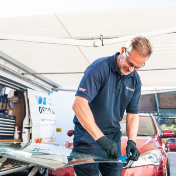technician performing panoramic glass roof replacement