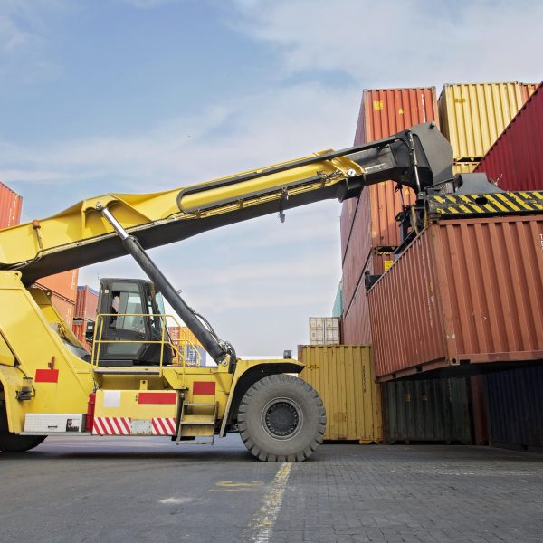 Crane lifting up container in a port.