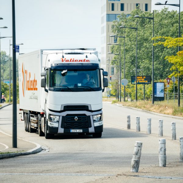 Front view of Renault truck driving fast on an empty highway at the border